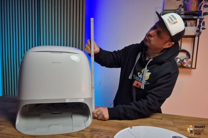 Die kompakte Station des Roborock Qrevo Curv 2 Pro wird im Test ausgemessen und die Höhe wird mit einem Zollstock geprüft.
